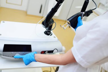 The cosmetologist holds a CO2 fractional ablative laser for skin rejuvenation and scar removal in his hands and prepares for the procedure.Laser cosmetology