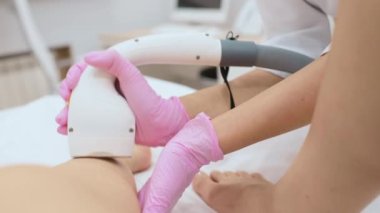 a cosmetologist performs laser hair removal of the patients legs in a modern cosmetology clinic. Hardware cosmetology