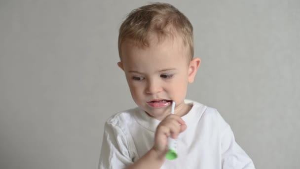 Dzieciak Myje Zęby Szczoteczką Zębów Szarym Tle Higiena Jamy Ustnej — Wideo stockowe