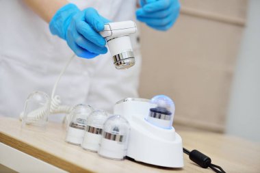 a close-up of a cosmetologist trichologist holds a device for computer diagnostics of the condition of hair and scalp. Trichoscopy, phototrichogram
