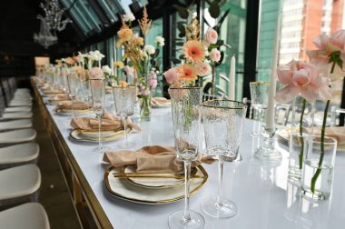 Çiçeklerin zarif dekoru ve düğün masasında zarif bir servis. Modern düğün dekorasyonu