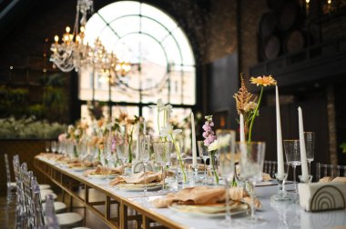 Çiçeklerin zarif dekoru ve düğün masasında zarif bir servis. Modern düğün dekorasyonu