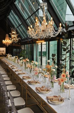 Çiçeklerin zarif dekoru ve düğün masasında zarif bir servis. Modern düğün dekorasyonu