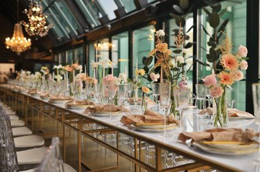 Çiçeklerin zarif dekoru ve düğün masasında zarif bir servis. Modern düğün dekorasyonu