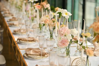 Çiçeklerin zarif dekoru ve düğün masasında zarif bir servis. Modern düğün dekorasyonu