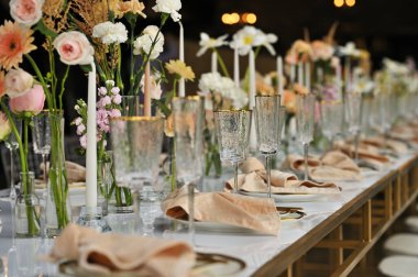 Çiçeklerin zarif dekoru ve düğün masasında zarif bir servis. Modern düğün dekorasyonu