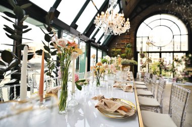 Çiçeklerin zarif dekoru ve düğün masasında zarif bir servis. Modern düğün dekorasyonu