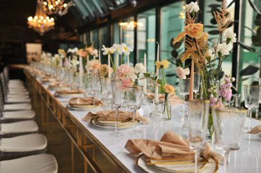 Çiçeklerin zarif dekoru ve düğün masasında zarif bir servis. Modern düğün dekorasyonu