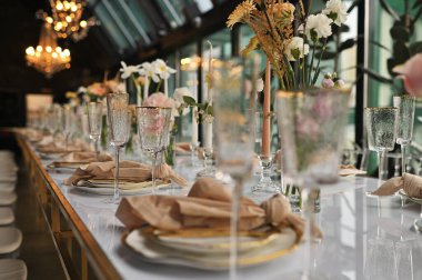 Çiçeklerin zarif dekoru ve düğün masasında zarif bir servis. Modern düğün dekorasyonu