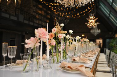 Çiçeklerin zarif dekoru ve düğün masasında zarif bir servis. Modern düğün dekorasyonu