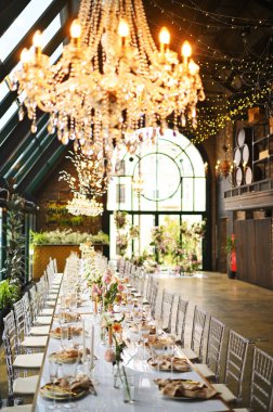 Çiçeklerin zarif dekoru ve düğün masasında zarif bir servis. Modern düğün dekorasyonu