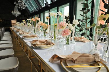 Çiçeklerin zarif dekoru ve düğün masasında zarif bir servis. Modern düğün dekorasyonu