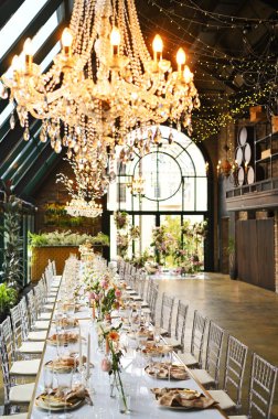 Çiçeklerin zarif dekoru ve düğün masasında zarif bir servis. Modern düğün dekorasyonu