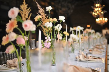 Çiçeklerin zarif dekoru ve düğün masasında zarif bir servis. Modern düğün dekorasyonu