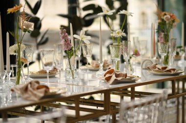 Çiçeklerin zarif dekoru ve düğün masasında zarif bir servis. Modern düğün dekorasyonu