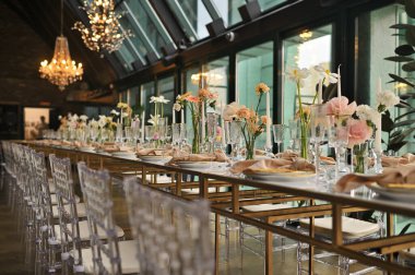 Çiçeklerin zarif dekoru ve düğün masasında zarif bir servis. Modern düğün dekorasyonu