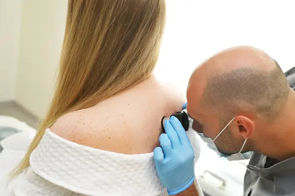 Een Dermatoloog Onderzoekt Neoplasma Huid Van Patiënt Met Behulp Van Stockfoto