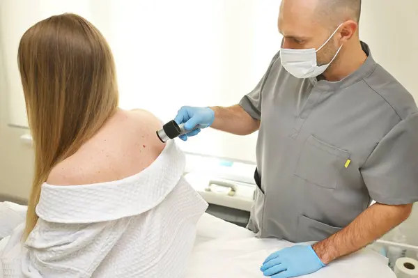 Dermatólogo Examina Las Neoplasias Piel Los Pacientes Utilizando Dispositivo Especial Imagen de stock