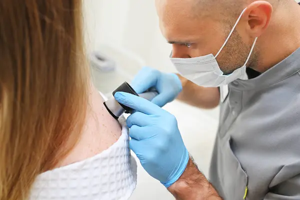Dermatólogo Examina Las Neoplasias Piel Los Pacientes Utilizando Dispositivo Especial Imagen De Stock