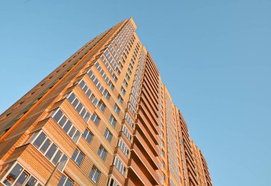 multi-storey new yellow brick house against the blue sky. Mortgage, real estate, new housing, copy space. clipart