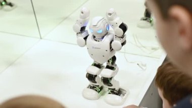 Rostov-on-Don, Russian Federation - December 27, 2022. Children watch a dancing robot at a robotics exhibition.