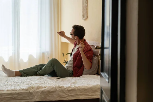 Kablosuz Kulaklıkla Müzik Dinleyen Beyaz Bir Adam Yatakta Tek Başına — Stok fotoğraf