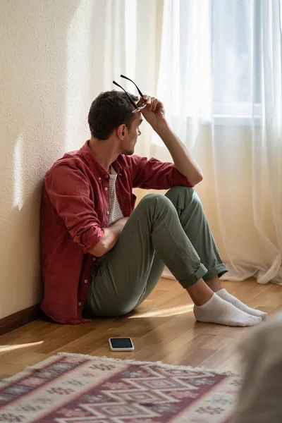 Frustrated European Man Sits Mobile Phone Floor Own Home Sadly — Stock Photo, Image