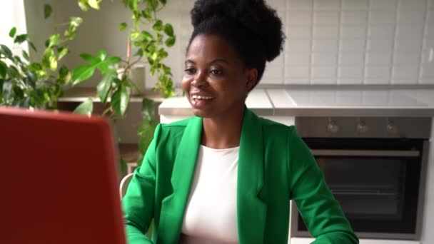 ビジネス服を着た若いアフリカ系アメリカ人女性がオンライン会議に参加するコンピュータの前に座って話をしている 社交的な女の子を通過するビデオインタビューまたは書き込み視覚的な履歴書のための仕事 — ストック動画