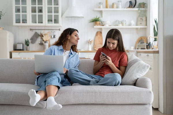 Adolescente Niña Hija Madre Joven Usando Gadgets Juntos Sentado Sofá —  Fotos de Stock