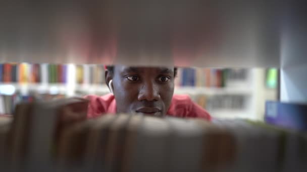 Üniversitede Okurken Özel Bir Kitap Arayan Genç Zenci Öğrenci Kitaplıkların — Stok video
