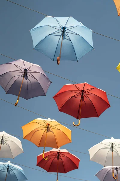 stock image Colorful umbrellas fixed on steel ropes between buildings against blue sky. Famous Umbrella street in center of old city of Antalya, Turkey. 