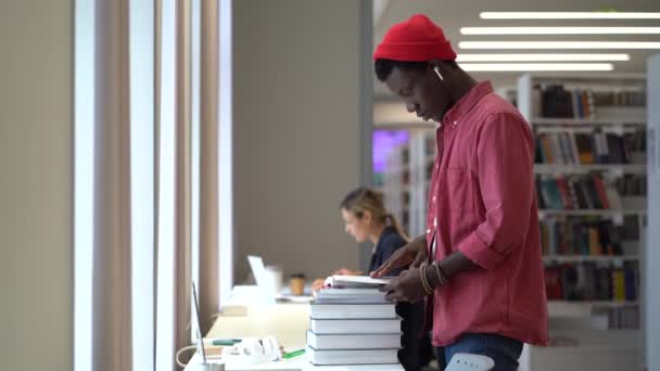 Młody Skupiony Afrykański Student Stojący Przy Biurku Stosem Książek Wykorzystujących — Wideo stockowe
