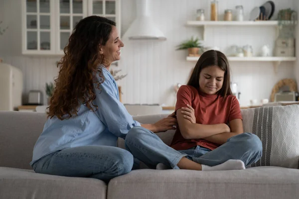 stock image Parenting an adolescent. Young loving mother trying to talk with stubborn resentful teenager daughter after argument at home, sitting together on sofa, mom trying to reconnect with child after fight