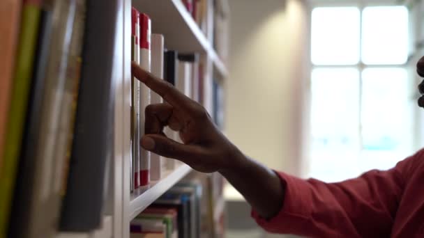 Молодий Афроамериканець Який Навчається Тисячолітті Вибирає Потрібну Книжку Книжкової Полиці — стокове відео
