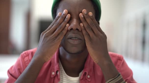 接近精疲力竭的千禧年非洲男生按摩眼睛 患有头痛或偏头痛 在图书馆长时间学习时感觉无动力 有选择地集中注意力 学习倦怠 — 图库视频影像