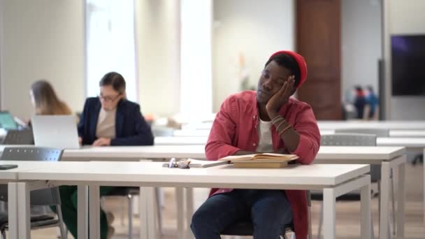 Vyčerpaný Africký Student Sedí Zavřenýma Očima Stolem Knihovně Usíná Unavený — Stock video