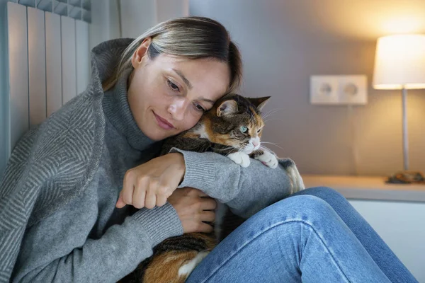 Young woman hugs domestic pet enjoying spending time with favourite cat. Animal makes owner happy and helps to walk through problems and bad thoughts. Female has motivation to make life better