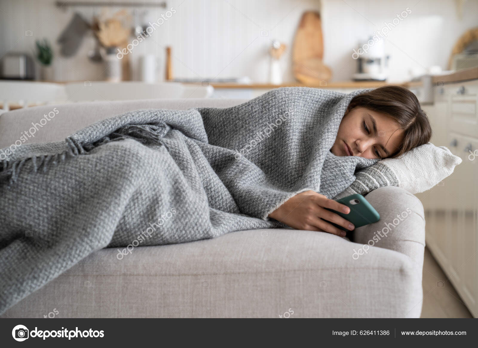 A menina encontra-se no sofá com o telefone. menina adolescente