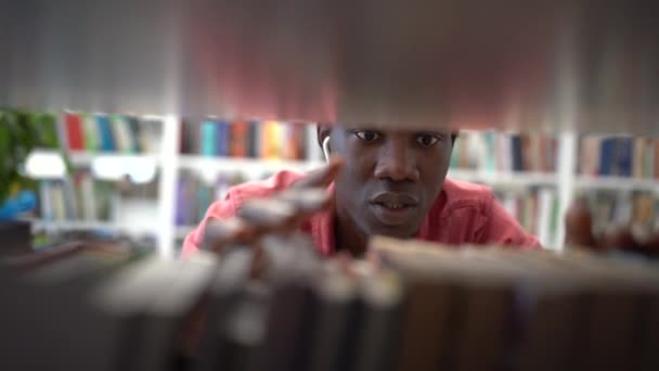Kütüphanede Rafın Yanında Duran Parmaklarını Rafta Gezdiren Titiz Bir Afrikalı — Stok video