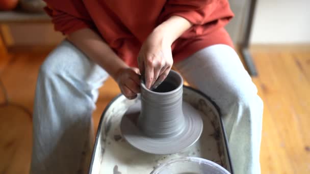 工房で手作りの陶器を作る女性陶芸家 陶器の車輪の上に形に粘土を成形し 形成するポッターショットを切り取った ストレス解消 クラフトビジネスコンセプトのためのアート活動 — ストック動画