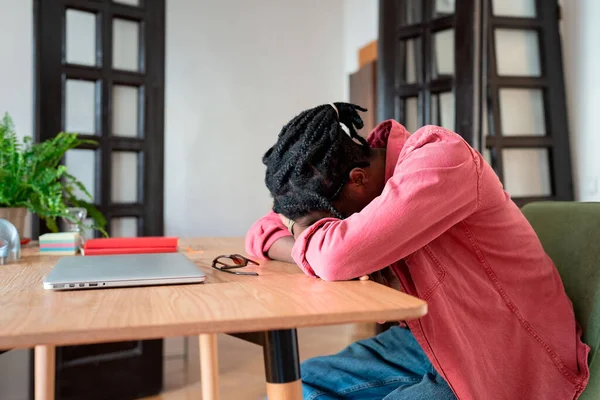 Freelancing and mental health. Young tired African guy remote worker sleeping at workplace, feeling unmotivated while working from home, suffering from digital exhaustion. Work-from-home burnout