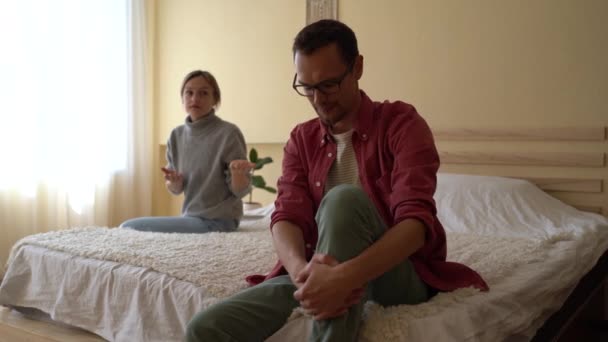 若い感情的な女性の妻は夫を非難し スマートフォンを捨て 関係に不満を感じ 議論中に離婚を脅かすことを強調した 家庭で口論している家族カップル — ストック動画