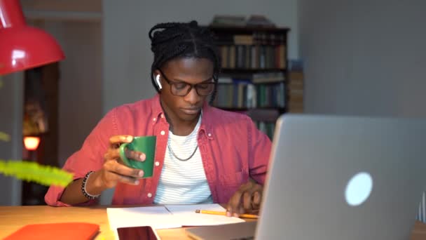 Συγκεντρωμένος Μαύρος Που Παρακολουθεί Online Μαθήματα Φορητό Υπολογιστή Κρατώντας Σημειώσεις — Αρχείο Βίντεο