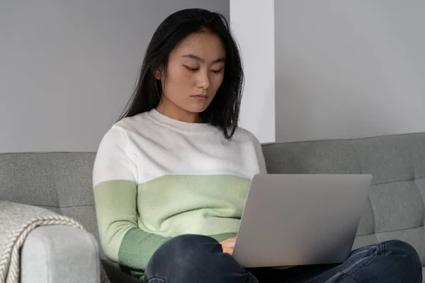 Concentrated Asian Woman Journalist Laptop Lap Sits Sofa Writing New — Stockfoto