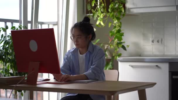 Разгневанная Азиатская Студентка Сидит Дома Компьютером Бросает Рабочую Тетрадь Стола — стоковое видео