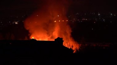 Alevlerden çıkan turuncu duman ya da bir katlı özel evin arkasında geceleri kamp ateşi. Yanan bina ya da bitişik bölge yangın güvenliği ihlalleri nedeniyle itfaiyecilerin ve kurtarıcıların gelmesini gerektiriyor.