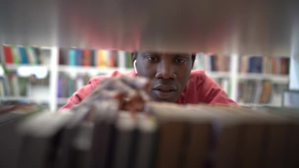 Boldogtalan Afroamerikai Srác Diák Keres Könyvet Könyvtári Polcon Megragadt Disszertáció — Stock videók