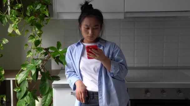 Serious Focused Young Asian Woman Standing Home Looking Mobile Phone — Wideo stockowe