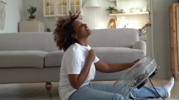 Υπερθέρμανση Στα Σπίτια Ευτυχισμένη Νεαρή Αφροαμερικανή Κάθεται Μπροστά Από Ηλεκτρικό — Αρχείο Βίντεο
