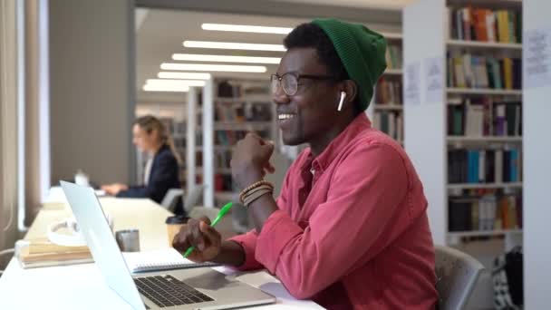 Mesafe Öğrenme Kütüphanede Otururken Kulaklık Takan Öğrencilerle Konuşan Internet Üzerinden — Stok video